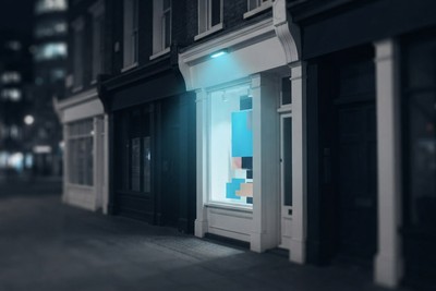 A small shop window lit by a cyan lamp on a dark street at night, standing out among the unlit storefronts