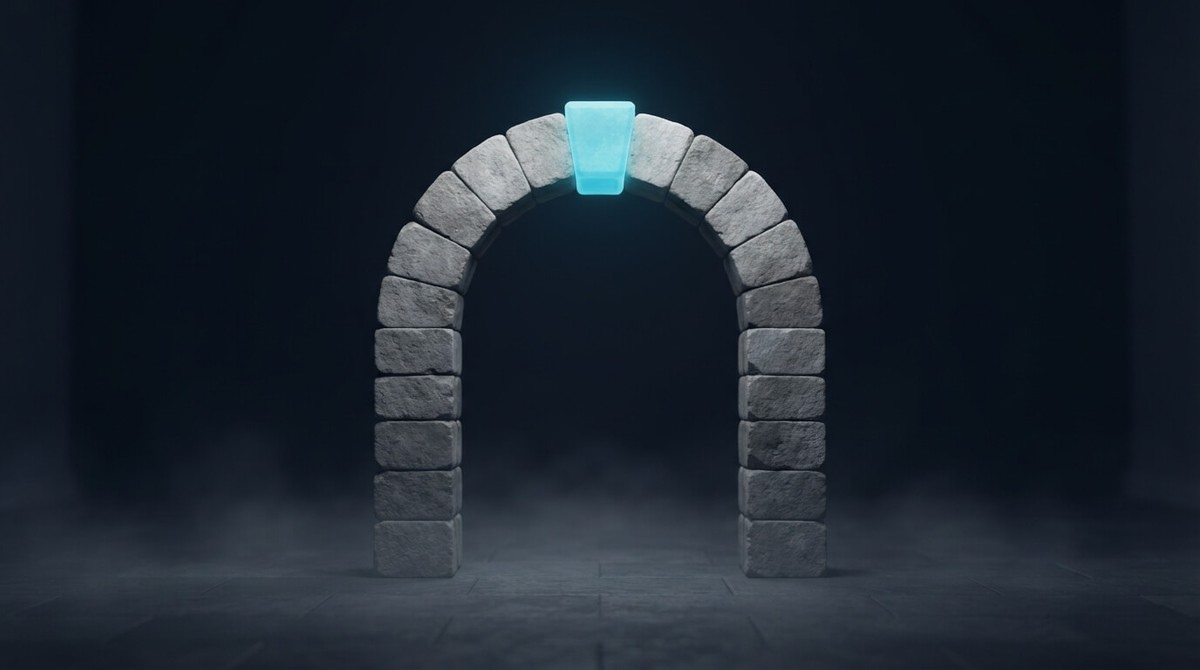 A freestanding stone arch of plain grey blocks in a dark hall, with a glowing cyan keystone at the top