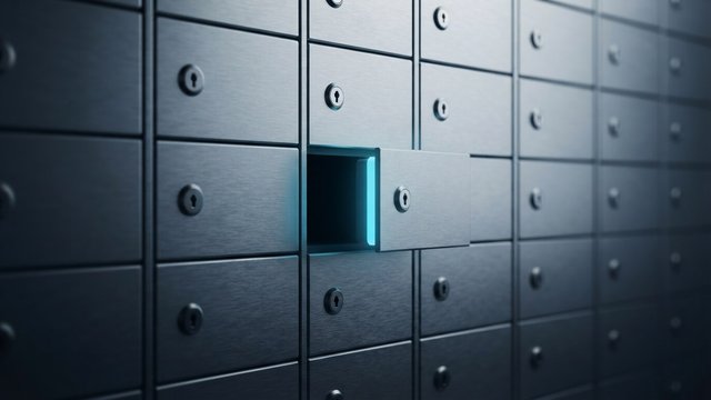 A wall of identical brushed-steel safe-deposit boxes with one drawer slid open and cyan light glowing from inside